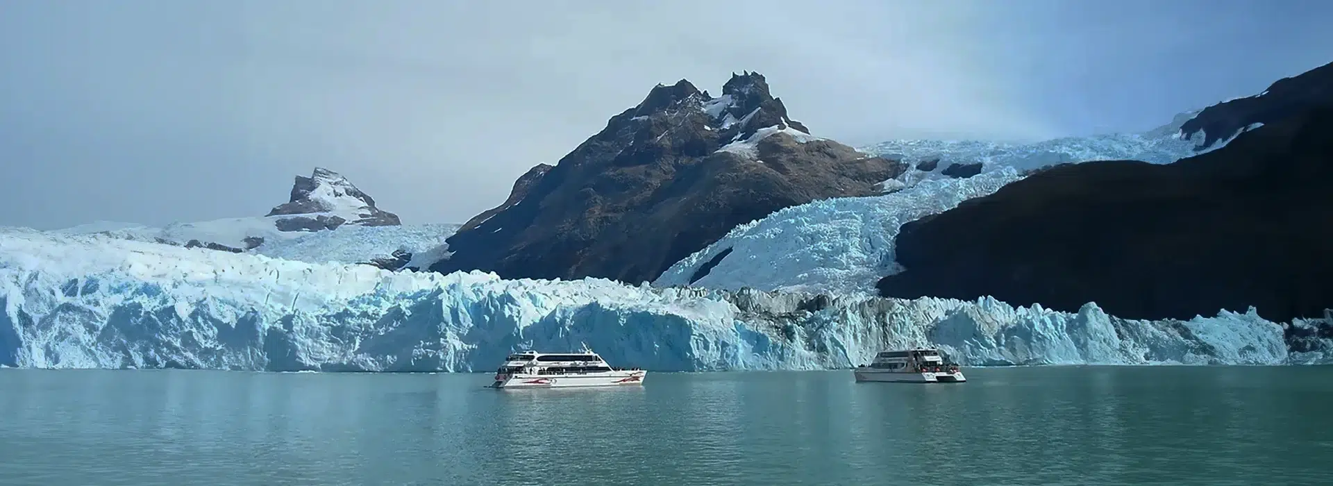 Turistas maravillados frente a la majestuosa pared de hielo del Glaciar Perito Moreno, una de las principales excursiones en El Calafate