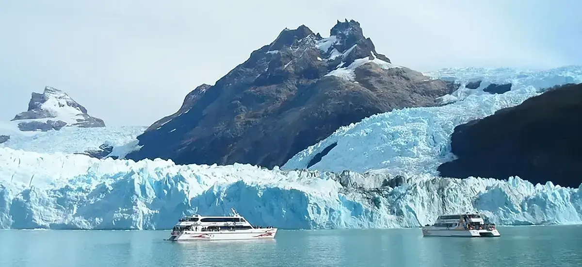 Barco navegando entre témpanos azules frente al Glaciar Upsala en el Brazo Norte del Lago Argentino