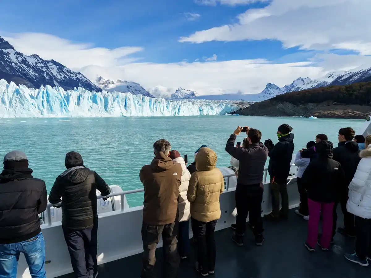 Catamarán navegando frente al imponente Glaciar Spegazzini, tour de navegación por el Parque Nacional Los Glaciares.