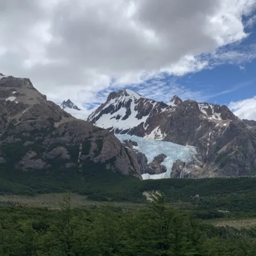 Glaciar Piedras Blancas colgando entre paredes de roca sobre el bosque del valle del río Blanco.